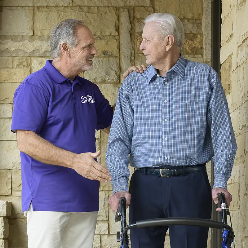 volunteer-serving-man Volunteer assisting elderly man with walker at VitalCaring.