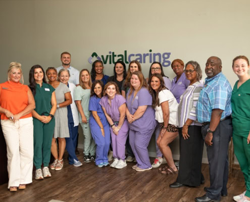 Diverse healthcare team at VitalCaring office, smiling and ready to serve patients.