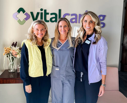 VitalCaring healthcare professionals smiling at reception.