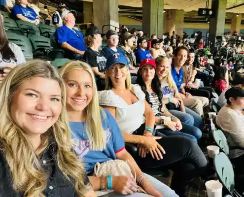 VitalCaring team watching a baseball game at VitalCaring stadium with a group of excited fans.