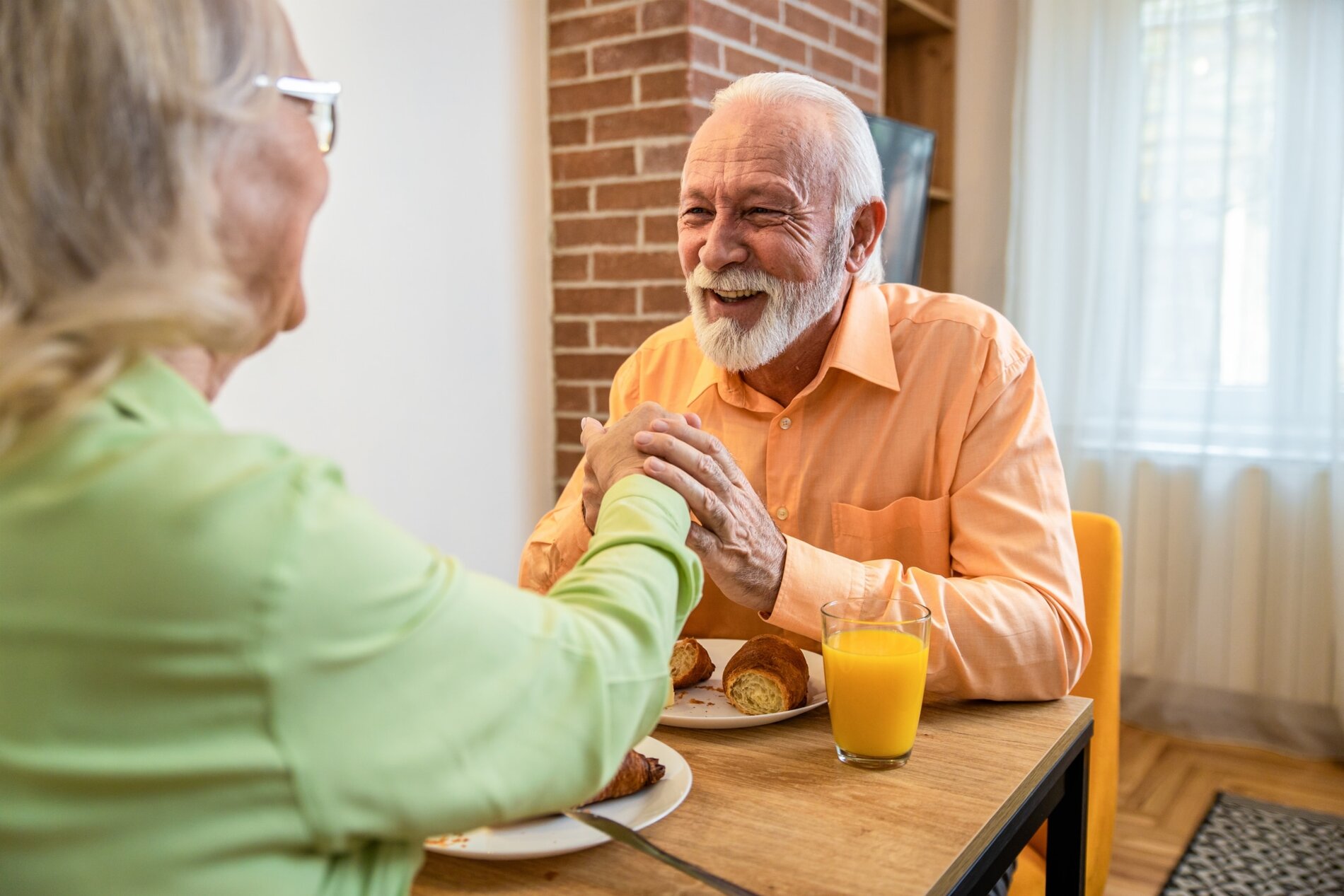 Senior couple enjoying a healthy breakfast, emphasizing thyroid health awareness for aging.