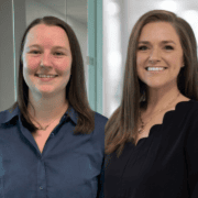 VitalCaring team members smiling in a professional office environment, showcasing compassionate heal.