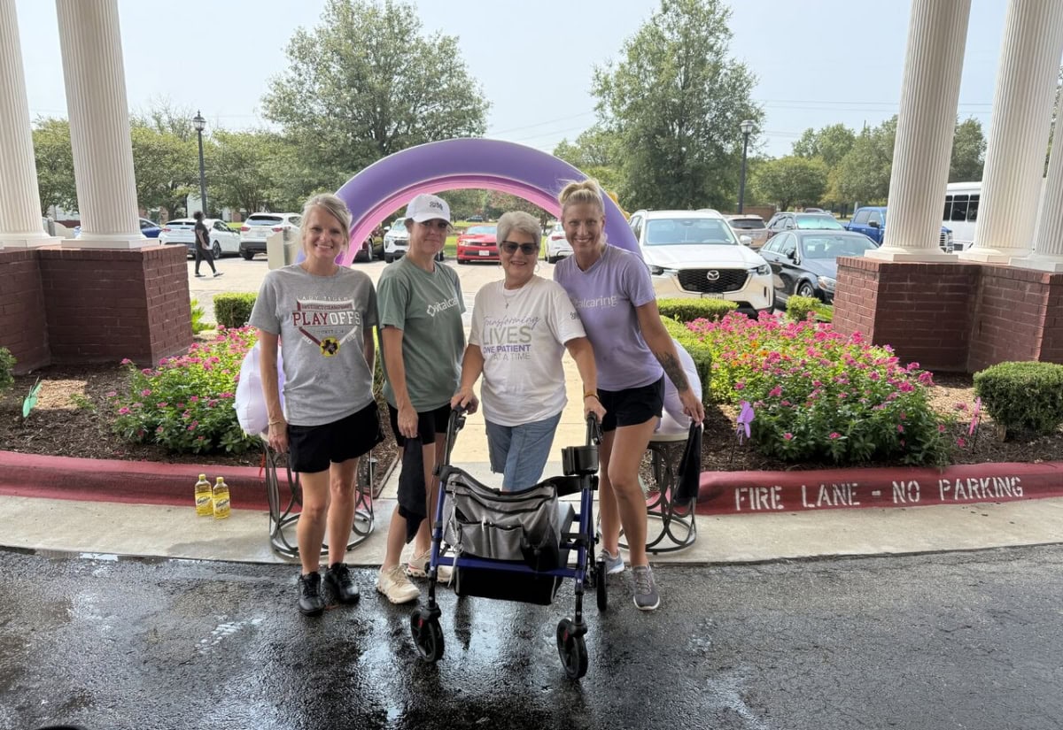 Group of four women with a wheelchair at a community event.