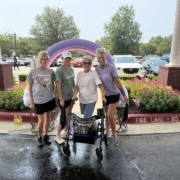 Group of four women with a wheelchair at a community event.