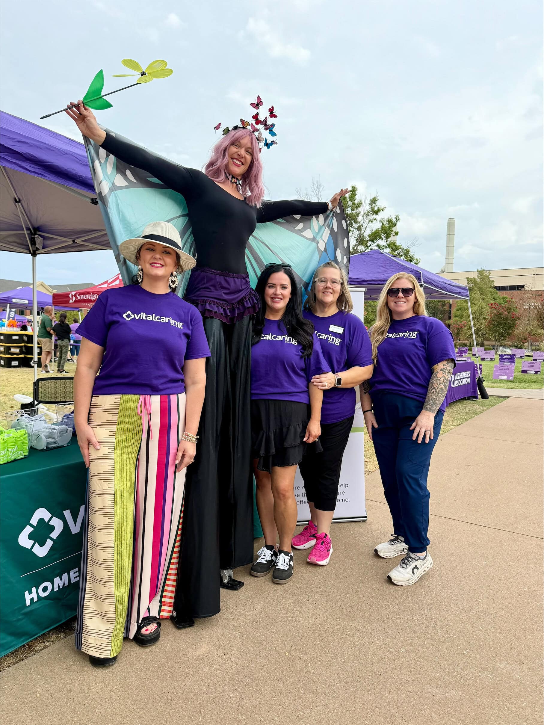 Group of women and a performer at VitalCaring outdoor event.